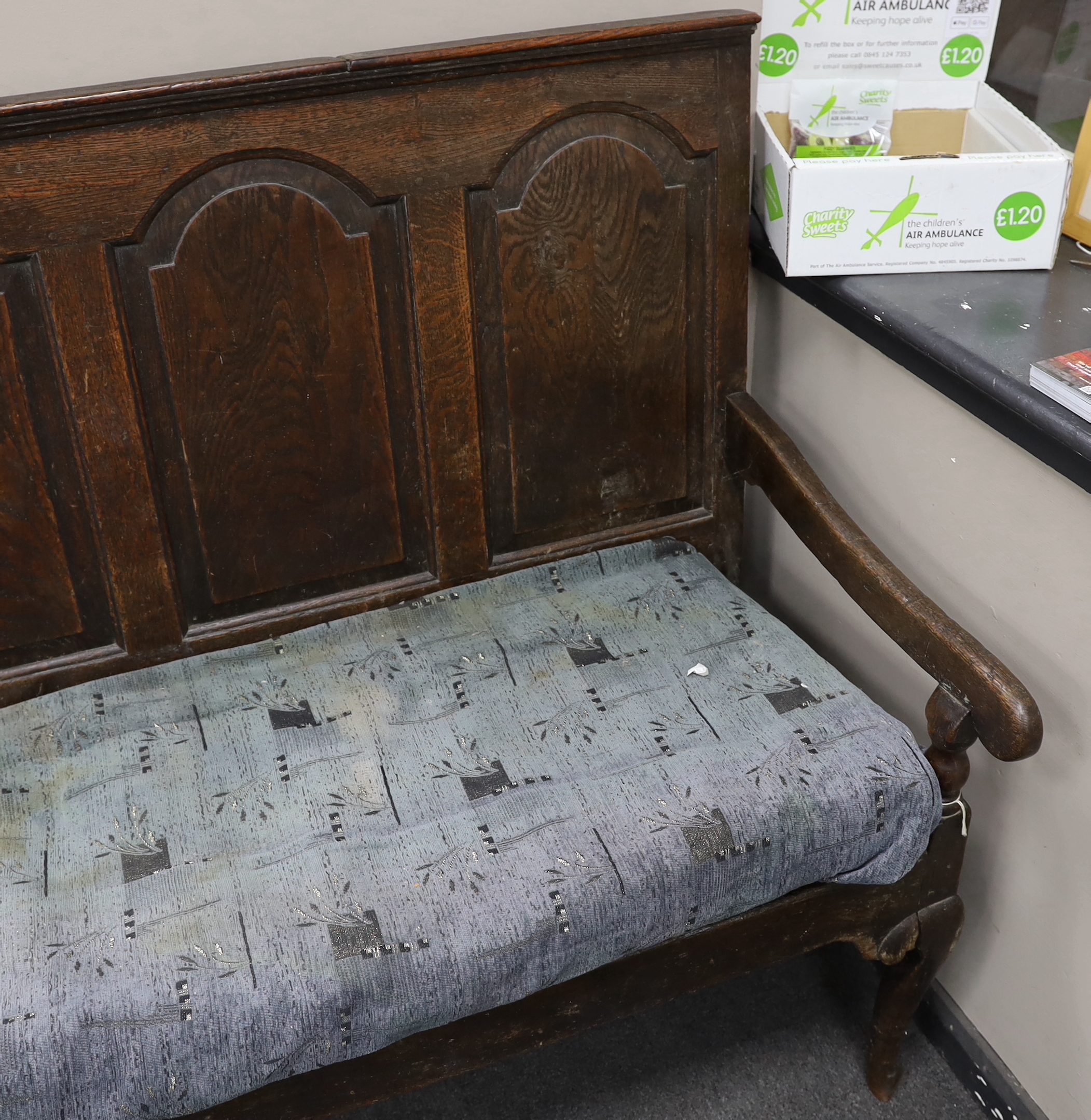 An 18th century panelled oak settle, with squab cushion seat, width 184cm, depth 65cm, height 112cm